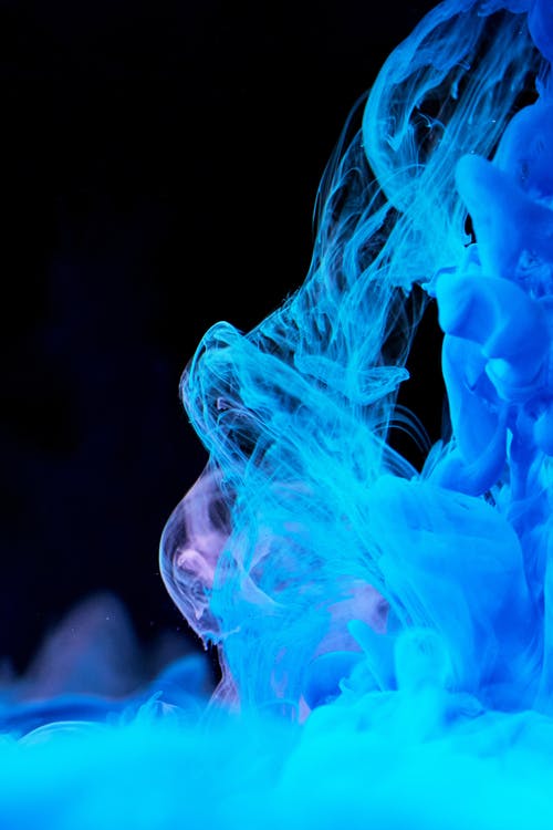 蓝色墨水在水中扩散的高速摄影 · 免费素材图片