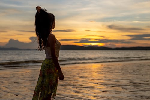 有关女人, 岸边, 日落的免费素材图片