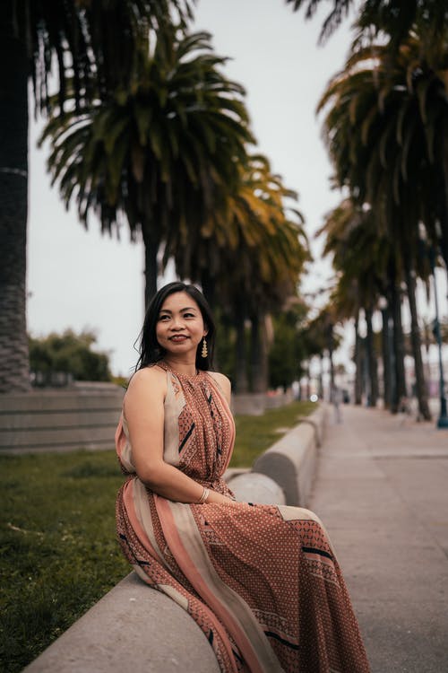 有关人行道, 双腿交叉在膝盖处, 坐的免费素材图片