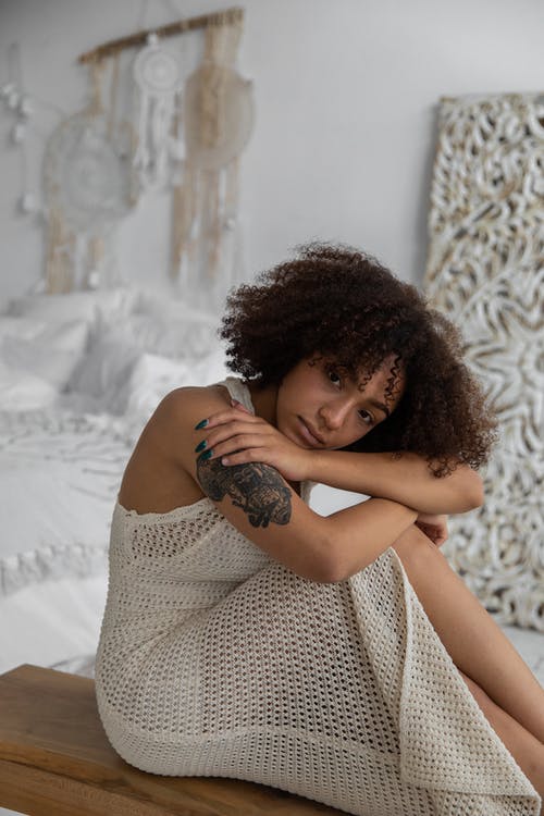 坐在卧室的纹身沉思黑女人 · 免费素材图片