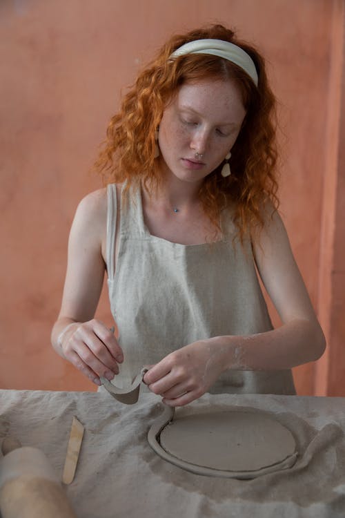 红发女人和黏土一起工作 · 免费素材图片