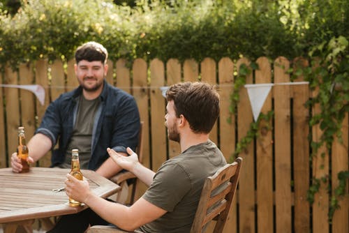 男性朋友喝啤酒，在后院聊天 · 免费素材图片