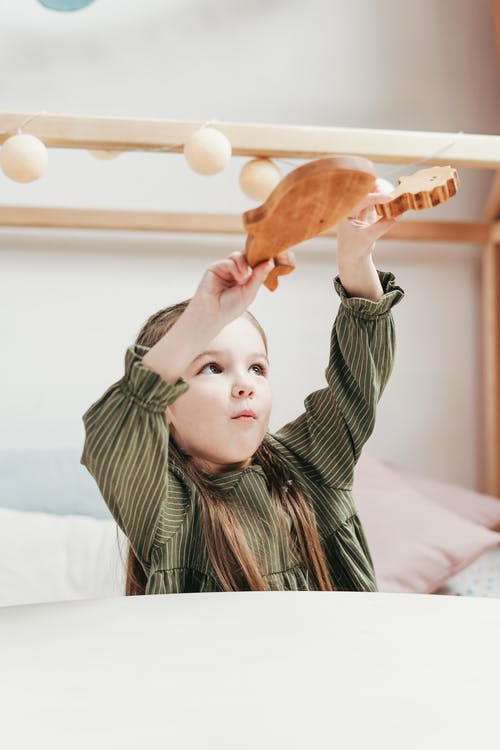 拿着棕色吉他的绿色和白色条纹长袖衬衫的女孩 · 免费素材图片