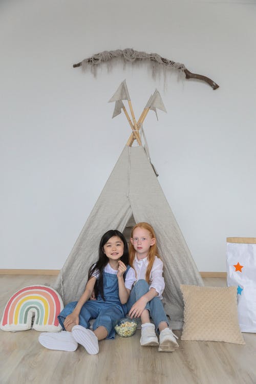 可爱小多样的孩子在家里的帐篷附近的地板上放松 · 免费素材图片