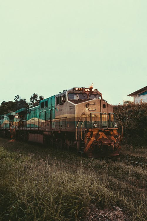 铁路轨道上的绿色和棕色火车 · 免费素材图片
