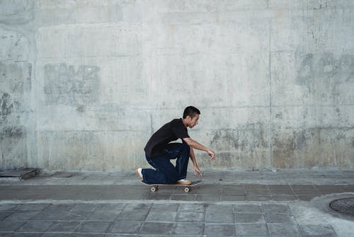 亚洲年轻男子在滑板上滑冰 · 免费素材图片