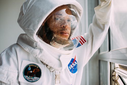 倚在窗户上的太空服的男人 · 免费素材图片