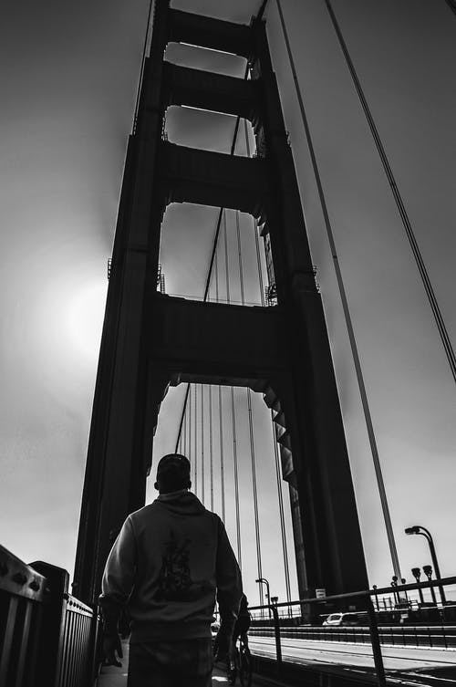 在吊桥上行走的人的单色照片 · 免费素材图片