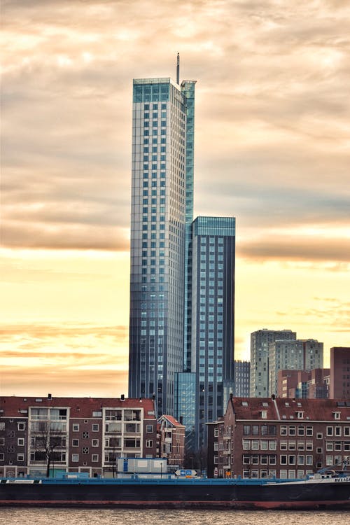 棕色多层建筑包围的灰色高层建筑 · 免费素材图片