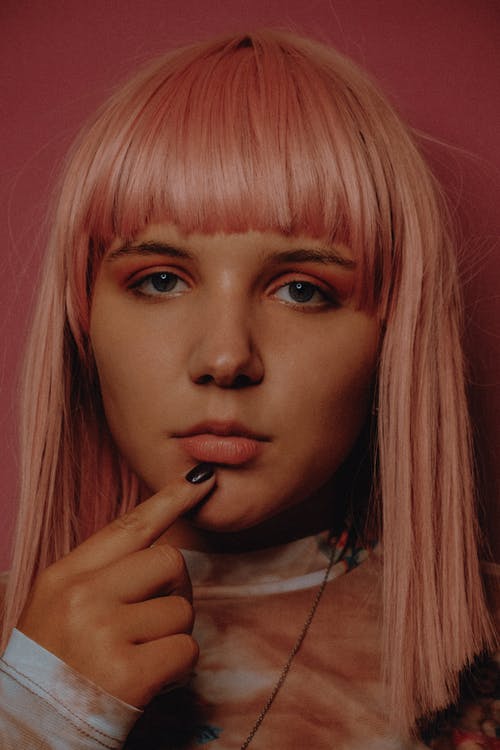 站立反对桃红色背景的时髦少妇 · 免费素材图片