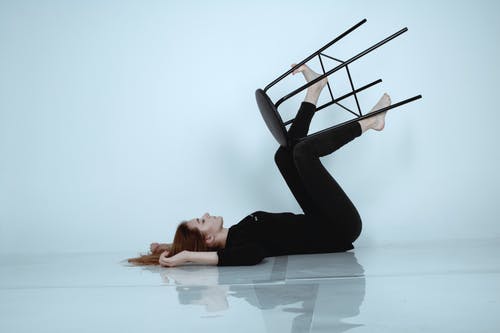 躺在地板上的黑色紧身裤的女人 · 免费素材图片