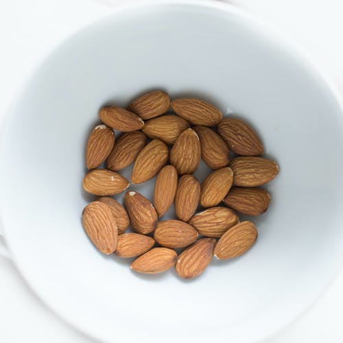 白色陶瓷碗上的棕色杏仁坚果 · 免费素材图片