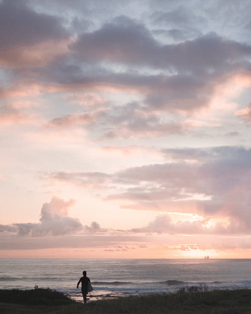 孤独的人，在打击海的海滩上行走 · 免费素材图片