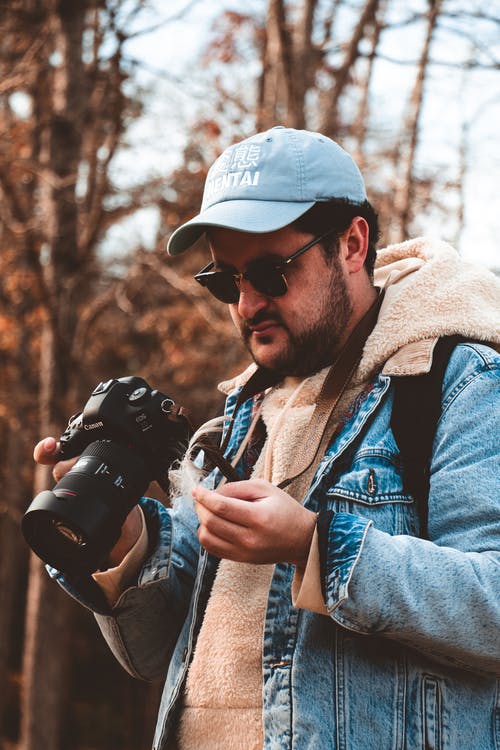 男子手持单反相机 · 免费素材图片