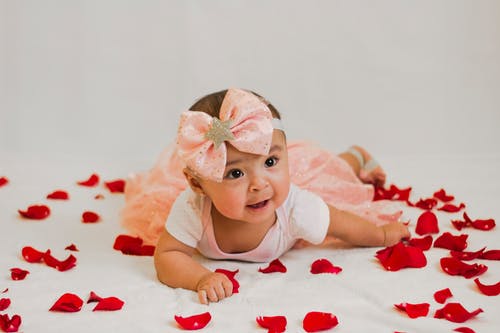 婴儿躺在花瓣上的衣服 · 免费素材图片