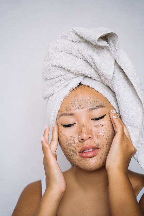 女人在她的脸上应用面霜 · 免费素材图片