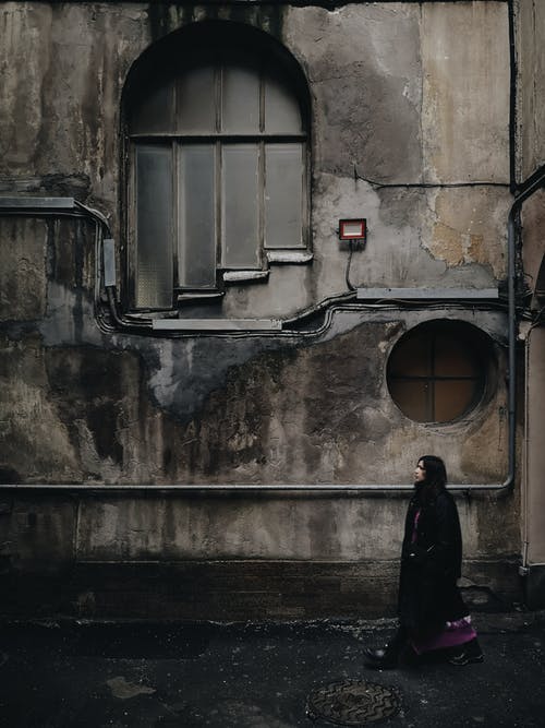 站在窗口前面的黑外套的女人 · 免费素材图片