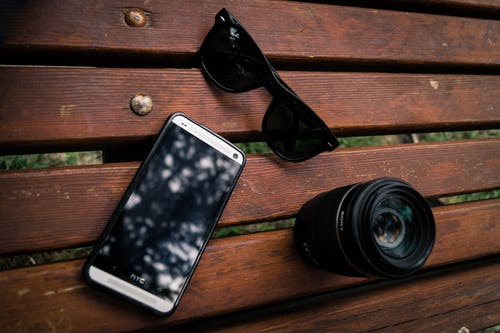 相机镜头附近的黑色wayfarer太阳镜 · 免费素材图片