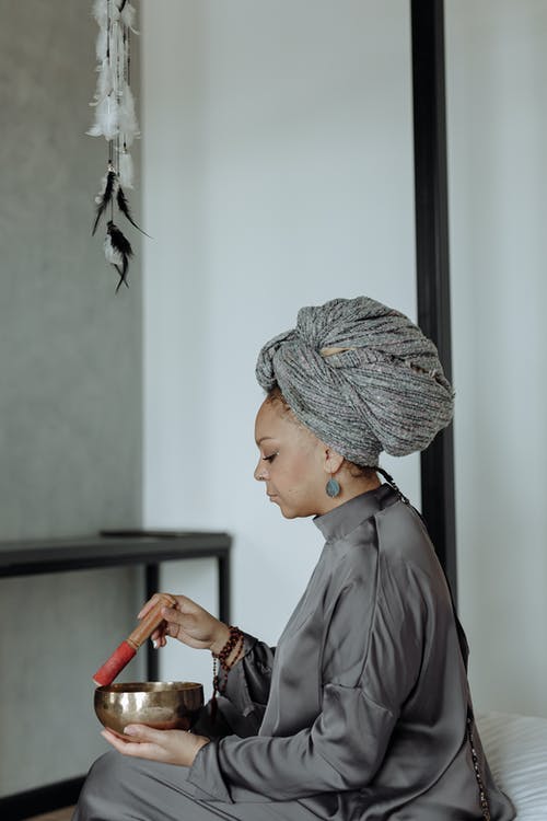 专注的女人使用藏文唱碗 · 免费素材图片