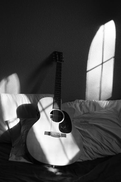 灰色和白色纺织品上的白色原声吉他 · 免费素材图片