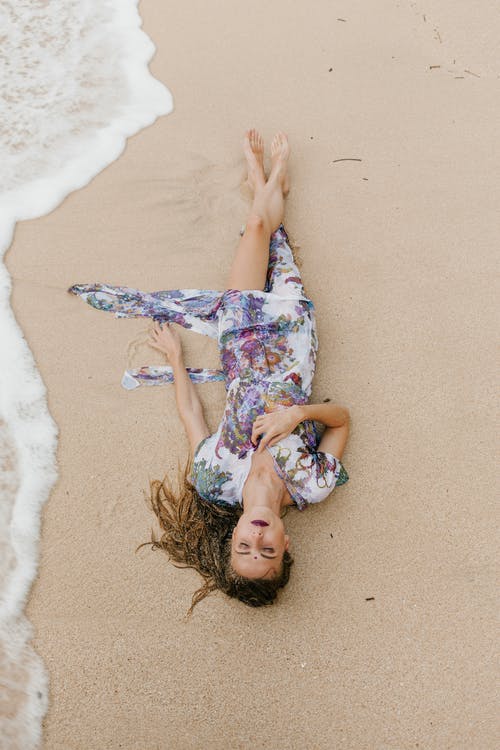 坦然的女人，穿着放松在海滩上 · 免费素材图片