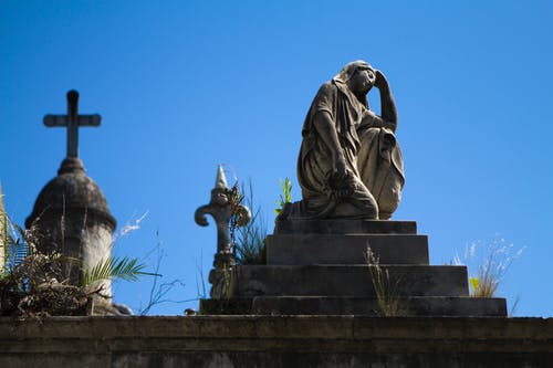 白天在十字架附近的女人雕像 · 免费素材图片