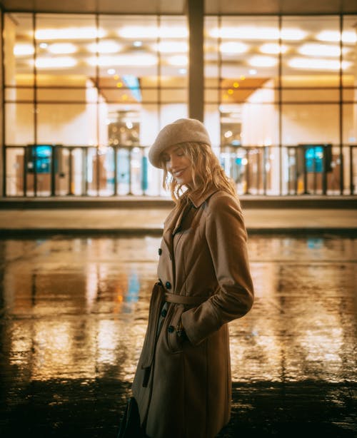 站在潮湿的道路上的棕色外套的女人 · 免费素材图片