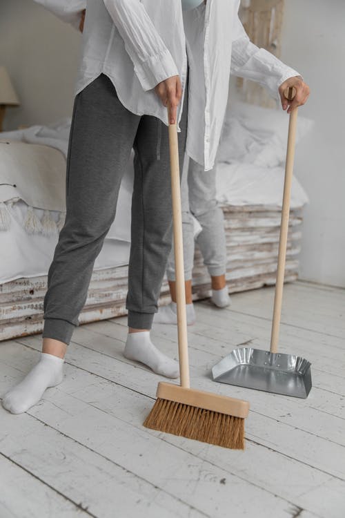 匿名妇女在家做家务时扫地 · 免费素材图片