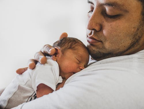 父亲抱着刚出生的婴儿的照片 · 免费素材图片