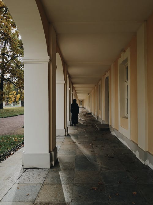 黑色的浴袍，在走廊上行走的人 · 免费素材图片