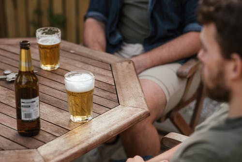 男子在后院野餐期间喝啤酒 · 免费素材图片