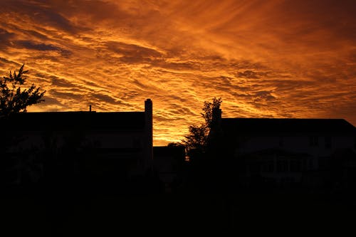 夕阳下的橙色天空下的建筑物的轮廓 · 免费素材图片