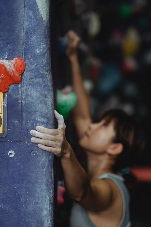 适合亚洲女人攀岩墙在健身房 · 免费素材图片