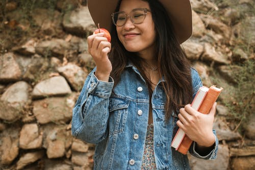 女人抱着一个苹果和书籍 · 免费素材图片