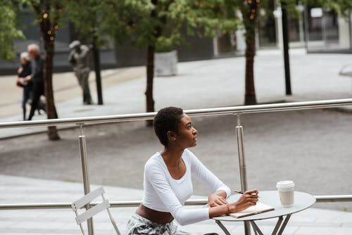 咖啡和笔记本的沉思黑女人 · 免费素材图片