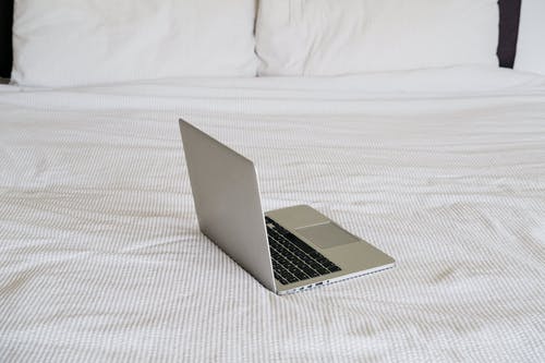 现代笔记本电脑上折痕的床罩在房子上 · 免费素材图片