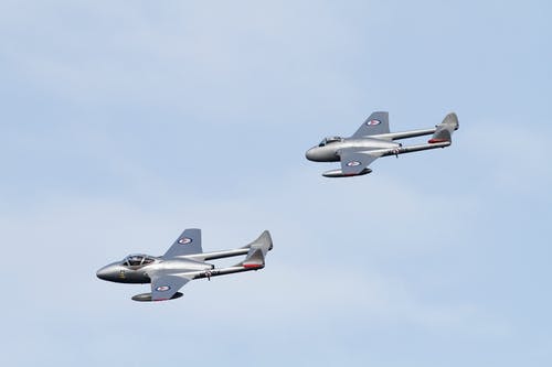 白天在空中的灰色喷气式飞机在蓝天下 · 免费素材图片