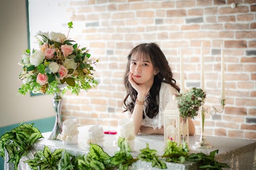 拿着花束的白色无袖礼服的妇女 · 免费素材图片