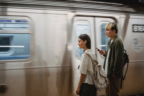 冷静亚洲夫妇站在火车平台上 · 免费素材图片