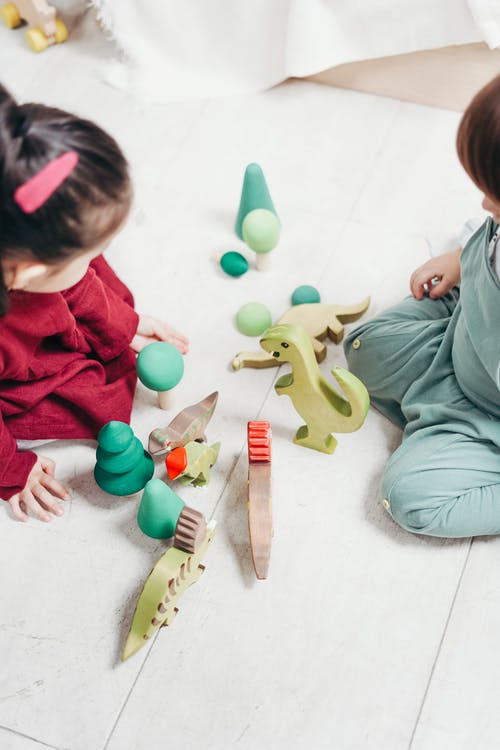 两个孩子坐下来玩玩具 · 免费素材图片