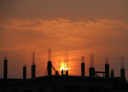 男子在日落时在建筑工地的剪影 · 免费素材图片