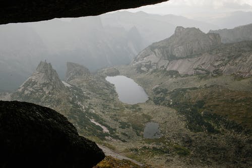 岩石粗糙的地层，与雾中的池塘 · 免费素材图片