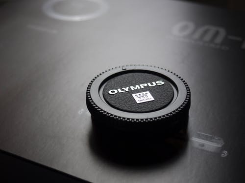 奥林巴斯相机镜头盖放在盒子上 · 免费素材图片