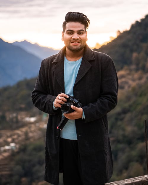 男子手持单反相机 · 免费素材图片