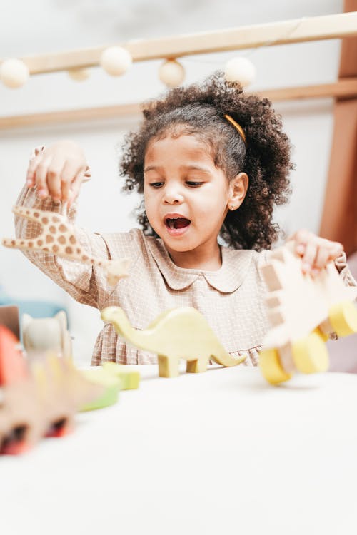 女孩抱着木制玩具在唱歌 · 免费素材图片