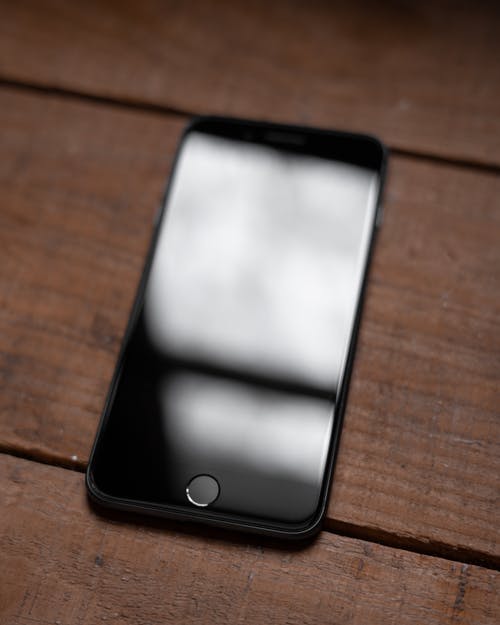 智能手机在木质表面上的照片 · 免费素材图片