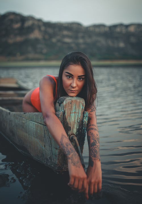 女人在木船上的浅焦点照片 · 免费素材图片