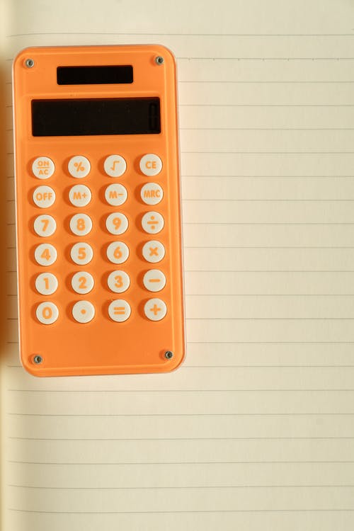 在白皮书上的橙色计算器 · 免费素材图片