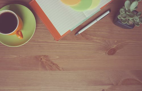 白色和灰色笔在肉质花卉和白色线纸旁边橙色陶瓷杯与黑咖啡 · 免费素材图片