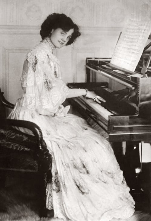 弹钢琴的白色连衣裙的女人 · 免费素材图片